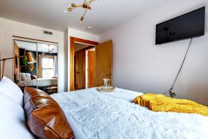 um quarto com uma cama e uma televisão na parede em Jungle House Luxury Homes - Columbus Downtown Short North - Walk to Convention Center & Nationwide Arena - Sleeps up to 10 - Free Parking - Over 5,800 Five Stars em Columbus