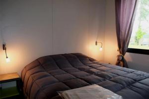 a bedroom with a large bed and a window at ZEcamping 3 étoiles pet friendly restaurant avec une vue panoramique in Gap
