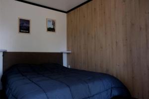 a bedroom with a bed with a wooden wall at ZEcamping 3 étoiles pet friendly restaurant avec une vue panoramique in Gap