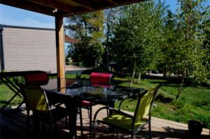 a patio with a table and chairs on a deck at ZEcamping 3 étoiles pet friendly restaurant avec une vue panoramique in Gap