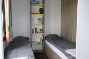 a bedroom with two beds and a book shelf at ZEcamping 3 étoiles pet friendly restaurant avec une vue panoramique in Gap