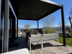 a wooden deck with white chairs and a table at ZEcamping 3 étoiles pet friendly restaurant avec une vue panoramique in Gap +66 photos