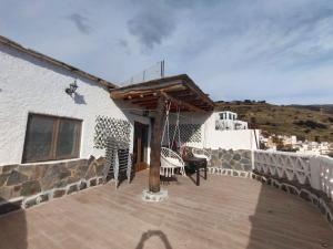 un patio avec des chaises et des tables sur un bâtiment dans l'établissement Casa Mirador, à Cáñar