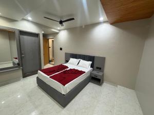 a bedroom with a large bed with a red blanket at OM Hotel in Sirohi