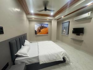 a bedroom with a bed with a ceiling fan at OM Hotel in Sirohi