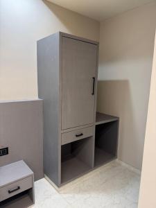 a cabinet in the corner of a room at OM Hotel in Sirohi