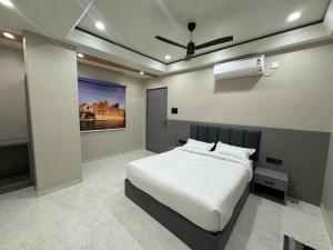 a bedroom with a bed and a painting on the wall at OM Hotel in Sirohi