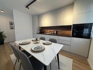 cocina con mesa blanca y sillas en una habitación en City Center Penthouse Mitrovice, en Kosovska Mitrovica
