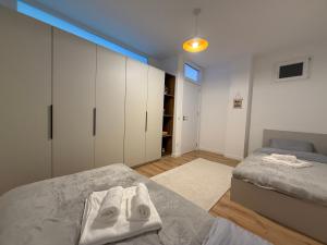 1 dormitorio con 2 camas y armarios blancos en City Center Penthouse Mitrovice, en Kosovska Mitrovica