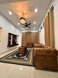 Una sala de estar con un sofá y un ventilador de techo. en Humairah Homestay - New House Near Bandar Temerloh, en Temerloh