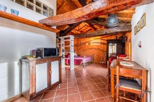 a kitchen and living room with wooden ceilings at Casa Puggimiano in Poggio Moiano