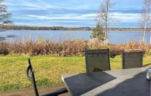 Amazing Home In Bolmsö With Sauna في Bolmsö: طاولة وكراسي مطلة على البحيرة +17 صورة