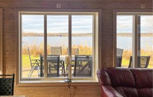 Amazing Home In Bolmsö With Sauna في Bolmsö: غرفة معيشة بها طاولة وكراسي وإطلالة على بحيرة