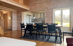 Amazing Home In Bolmsö With Sauna في Bolmsö: غرفة طعام ومطبخ مع طاولة وكراسي