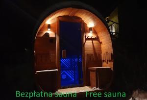 ZachełmieにあるOmszałe Głazy Mossy Rocks Dom na wyłącznośćの青い扉のアーチ道