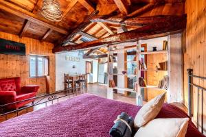 a bedroom with a purple bed in a room with wooden walls at Casa Puggimiano in Poggio Moiano