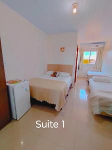 Camelo locação de Suítes Individuais Pousada com Cozinha e Sala Compartilhada في أرويو دو سيلفا: غرفة فندقية بسريرين وثلاجة