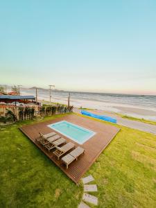 Una vista aérea de una piscina y la playa. en Austral Suítes à Beira-Mar, en Imbituba