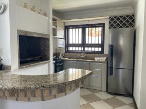 a kitchen with a refrigerator and a counter top at Sobrado em Imbé - RS in Imbé
