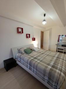 a bedroom with a bed with a plaid blanket at Glauque Room Horror and cinema themed studio in Béziers +67 photos