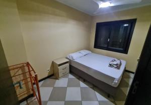 a small bedroom with a bed and a window at Sobrado em Imbé - RS in Imbé