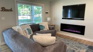 een woonkamer met twee banken en een flatscreen-tv bij Beachcomber in New Buffalo