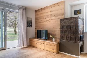 a living room with a tv and a wooden wall at iFlat Pinzolo Apartment Gufo in Pinzolo