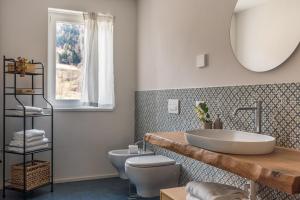 a bathroom with a sink and a toilet and a mirror at iFlat Pinzolo Apartment Gufo in Pinzolo +22 photos