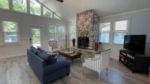 a living room with a couch and a stone fireplace at Sandy Shores in Union Pier