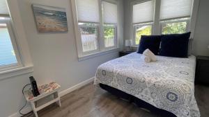 a bedroom with a bed with blue pillows and windows at Sandy Shores in Union Pier +26 photos