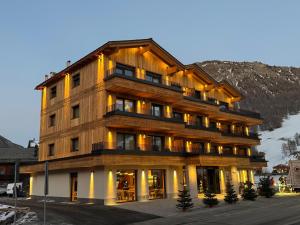 un gran edificio de madera con muchas ventanas en Hotel Damelis, en Livigno