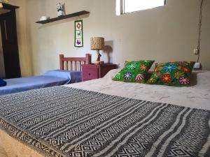 a bedroom with two beds and a table with a lamp at Casona de los Molles in Tilcara +10 photos