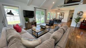 White Sands في Union Pier: غرفة معيشة مع أريكة وتلفزيون