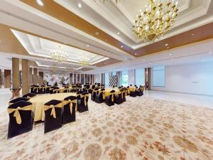Un gran salón de banquetes con mesas y sillas negras y doradas. en Sunday Resort & Spa by CheckIn Manesar Gurugram, en Gurgaon 68 fotos más