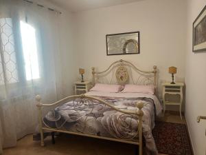a bedroom with a bed and two tables and a window at Camelia in Gubbio