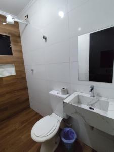 Un baño con un inodoro blanco y un lavabo. en Hotel-Motel Novo Oasis, en São Paulo