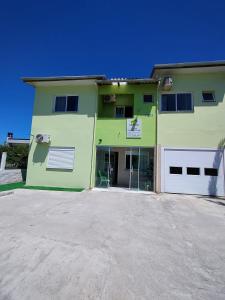 Camelo locação de Suítes Individuais Pousada com Cozinha e Sala Compartilhada في أرويو دو سيلفا: عماره خضراء وامامها موقف