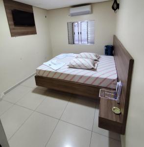 Una cama en una habitación con un cartel. en Hotel-Motel Novo Oasis, en São Paulo