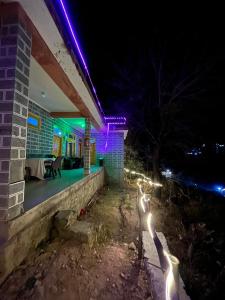 Una casa con luces en el costado por la noche. en Royal Mount, en Kasol 10 fotos más