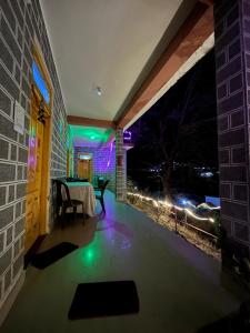 Un patio con mesa, sillas y luces. en Royal Mount, en Kasol