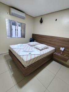 Un dormitorio con una cama grande con cabecero de madera. en Hotel-Motel Novo Oasis, en São Paulo