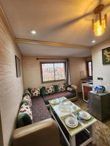 een woonkamer met een bank en een tafel bij Residence Imlil Ouarzazate in Ouarzazate