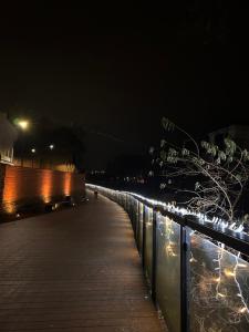a boardwalk at night next to a fence with lights at Apartament w Słupsku centrum bezpłatny parking in Słupsk