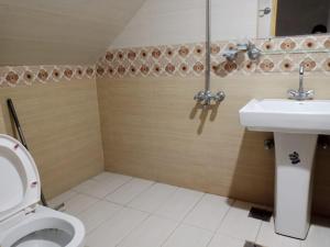a bathroom with a toilet and a sink at Islamabad Pak Palace guest house in Islamabad