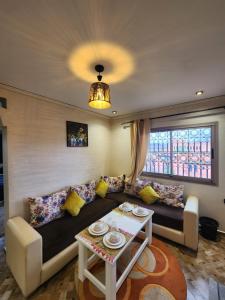 een woonkamer met een bank en een tafel bij Residence Imlil Ouarzazate in Ouarzazate
