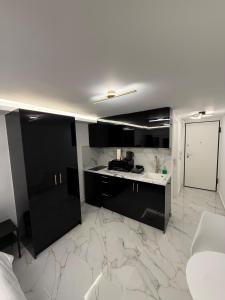 a kitchen with black cabinets and a marble floor at City Center Lux Studio in Athens +1 photo