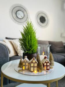 a coffee table with miniature houses and a candle at Apartament w Słupsku z klimatyzacją balkonem parkingiem in Słupsk