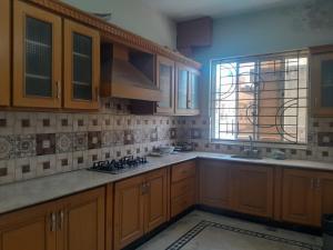 a kitchen with wooden cabinets and a window at Islamabad Pak Palace guest house in Islamabad +7 photos