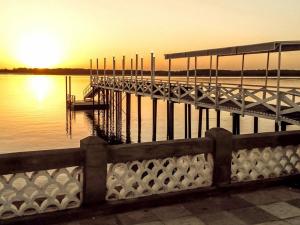 カモシンにあるapartamento Aconchego 1の夕日の水の上の桟橋