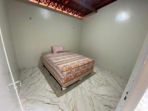 カモシンにあるapartamento Aconchego 1の大理石フロアの客室のベッド1台分です。